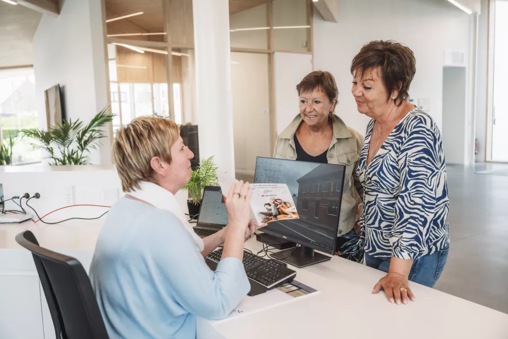 2 bezoekers krijgen toelichting over het advies van acasus aan de onthaalbalie